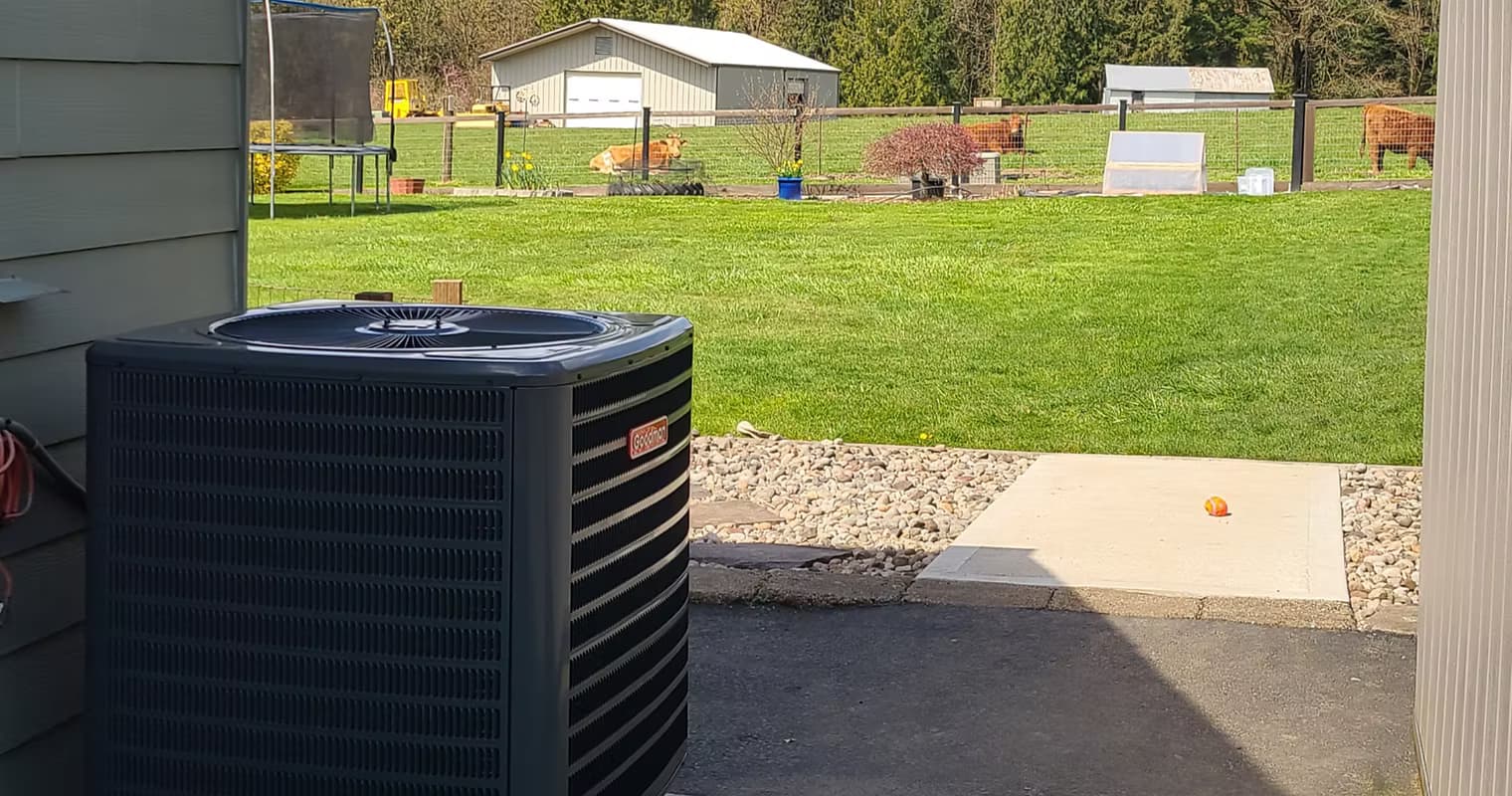 A residential AC condenser unit beside a home