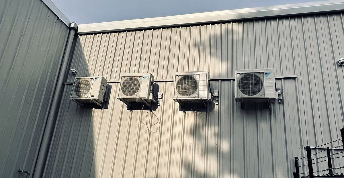 Bank of four wall-mounted condensers on a metal building
