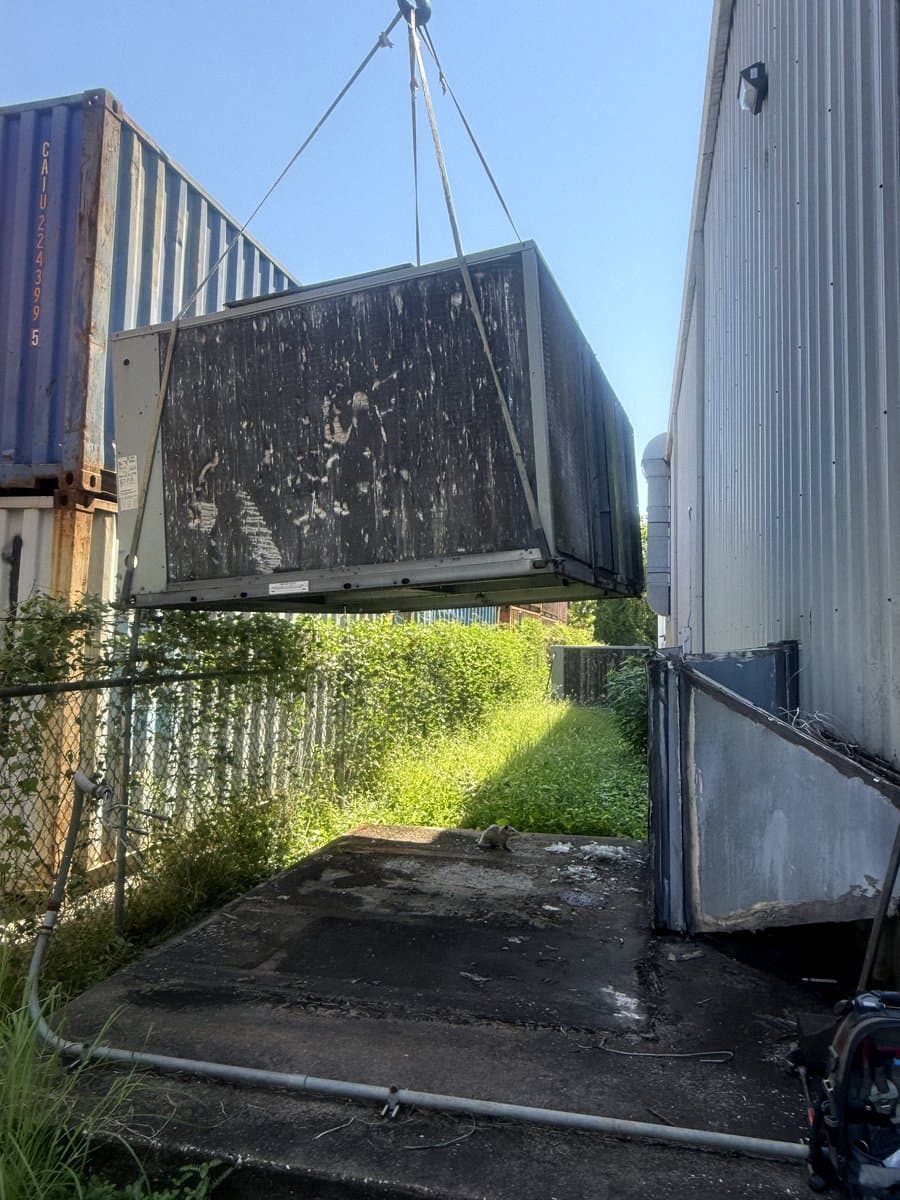 Air handler suspended from a crane during a change-out